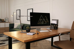 Workplace with computer on wooden desk in light room. Modern interior design